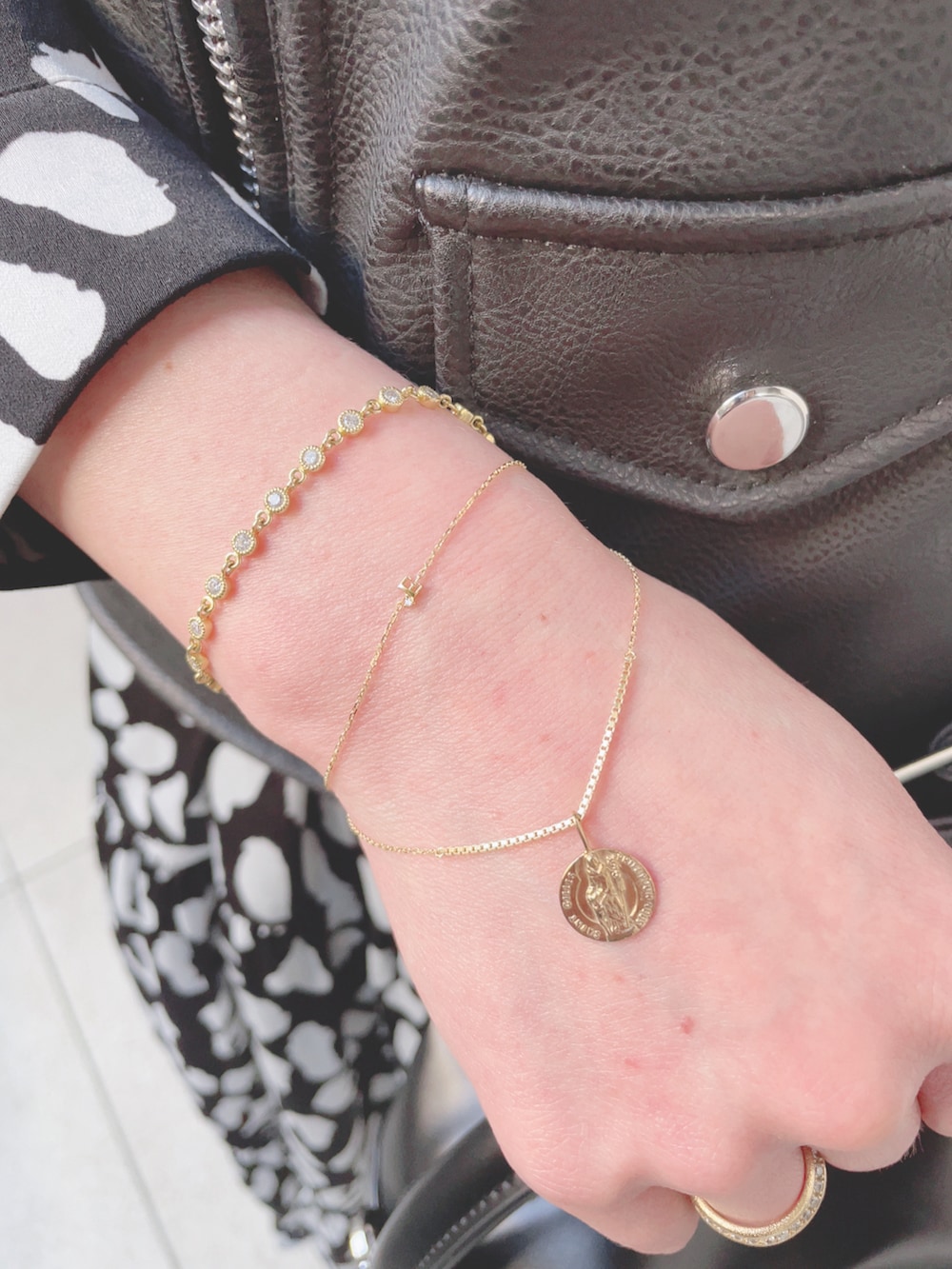 ブラック系のライダースジャケット、ブラック系のワンピース、ブラック系のハンドバッグを着用したレディースの春コーディネートの4枚目の写真