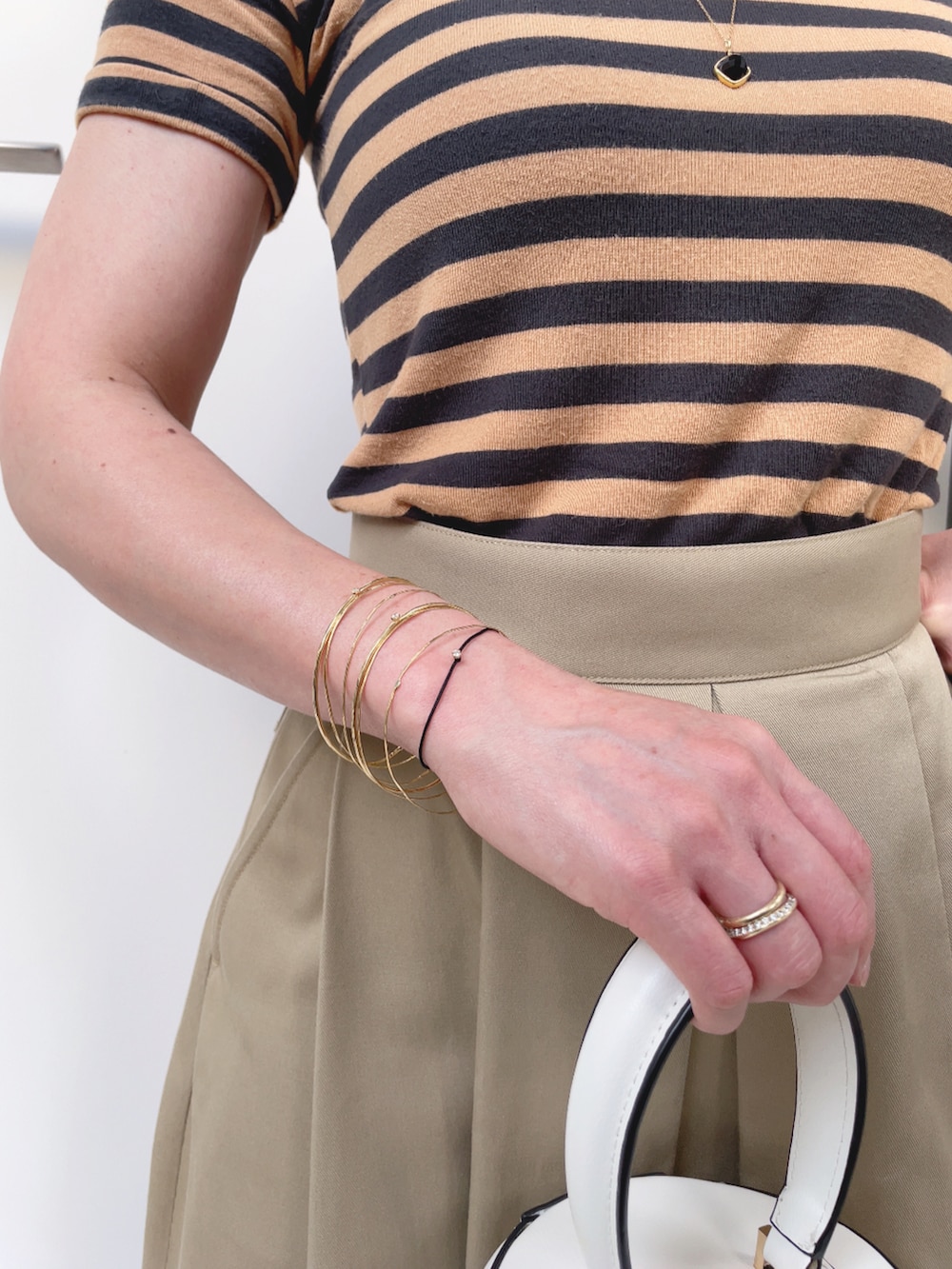 ベージュ系のスカート、ホワイト系のバッグ、ベージュ系のスニーカーを着用したレディースの夏コーディネートの4枚目の写真