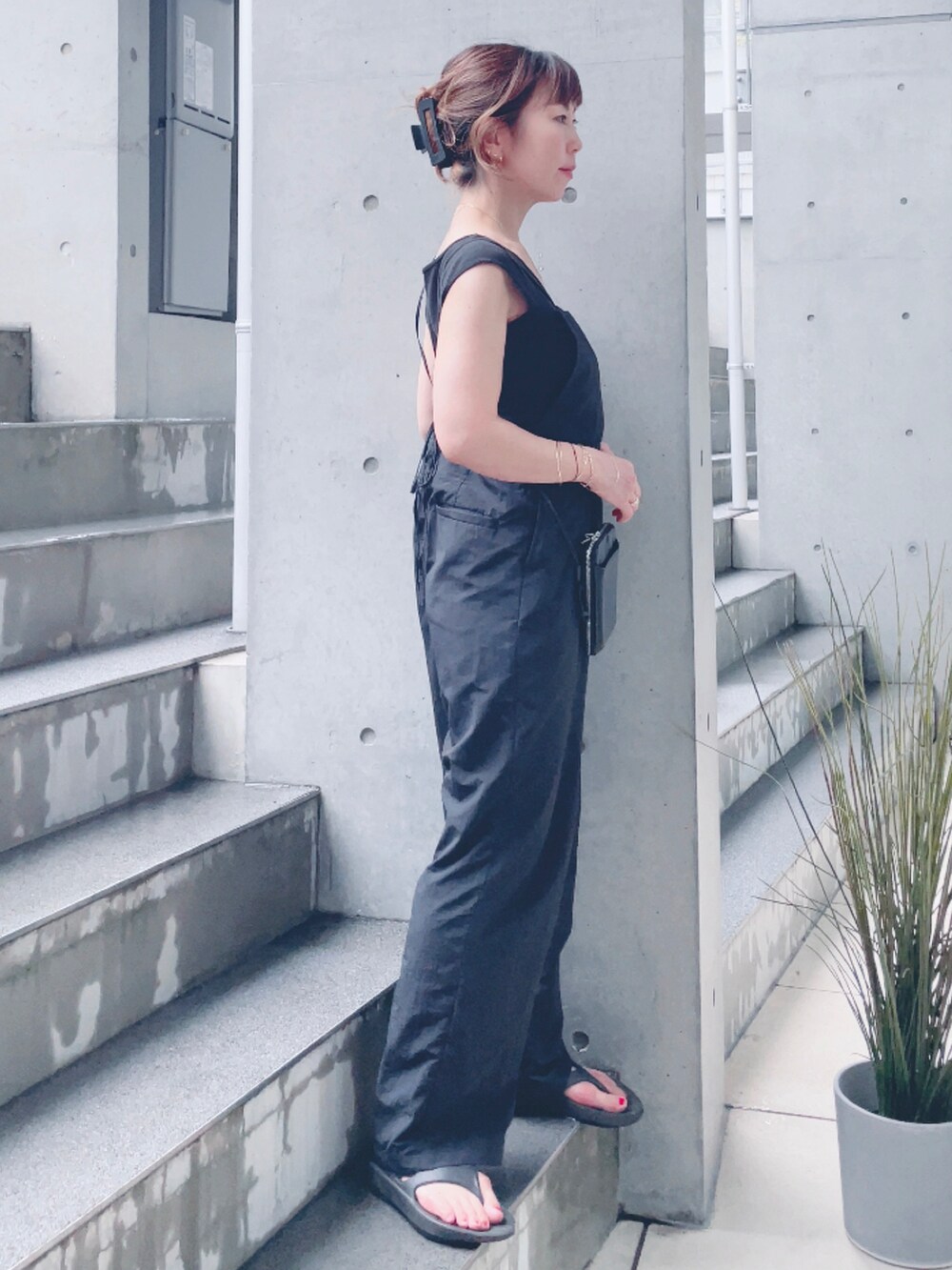 ブラック系のサロペット/オーバーオール、ブラック系のサンダル、ブラック系のポーチを着用したレディースの夏コーディネートの2枚目の写真