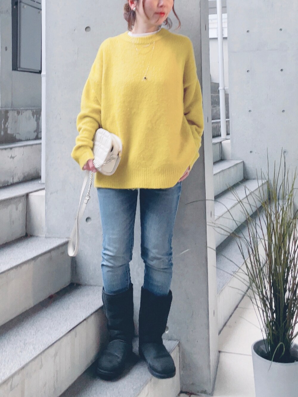 ブルー系のデニムパンツ、イエロー系のニット/セーターを着用したレディースの冬コーディネートの4枚目の写真