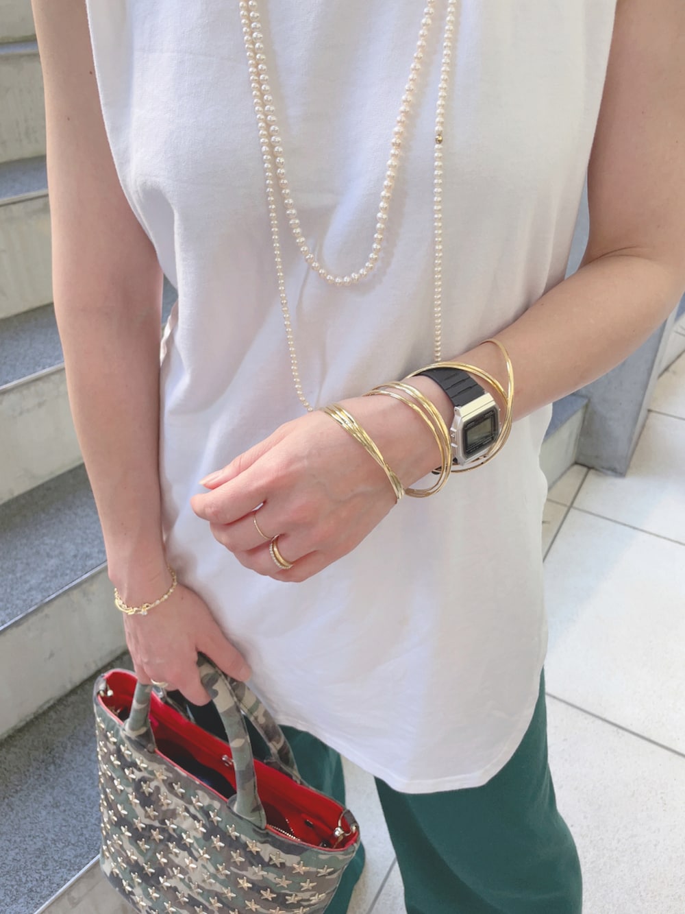 グリーン系のその他パンツ、ホワイト系のタンクトップ、グリーン系のトートバッグを着用したレディースの夏コーディネートの3枚目の写真