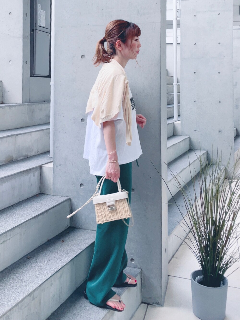 グレー系のTシャツ/カットソー、グリーン系のその他パンツ、ホワイト系のかごバッグを着用したレディースの夏コーディネートの2枚目の写真