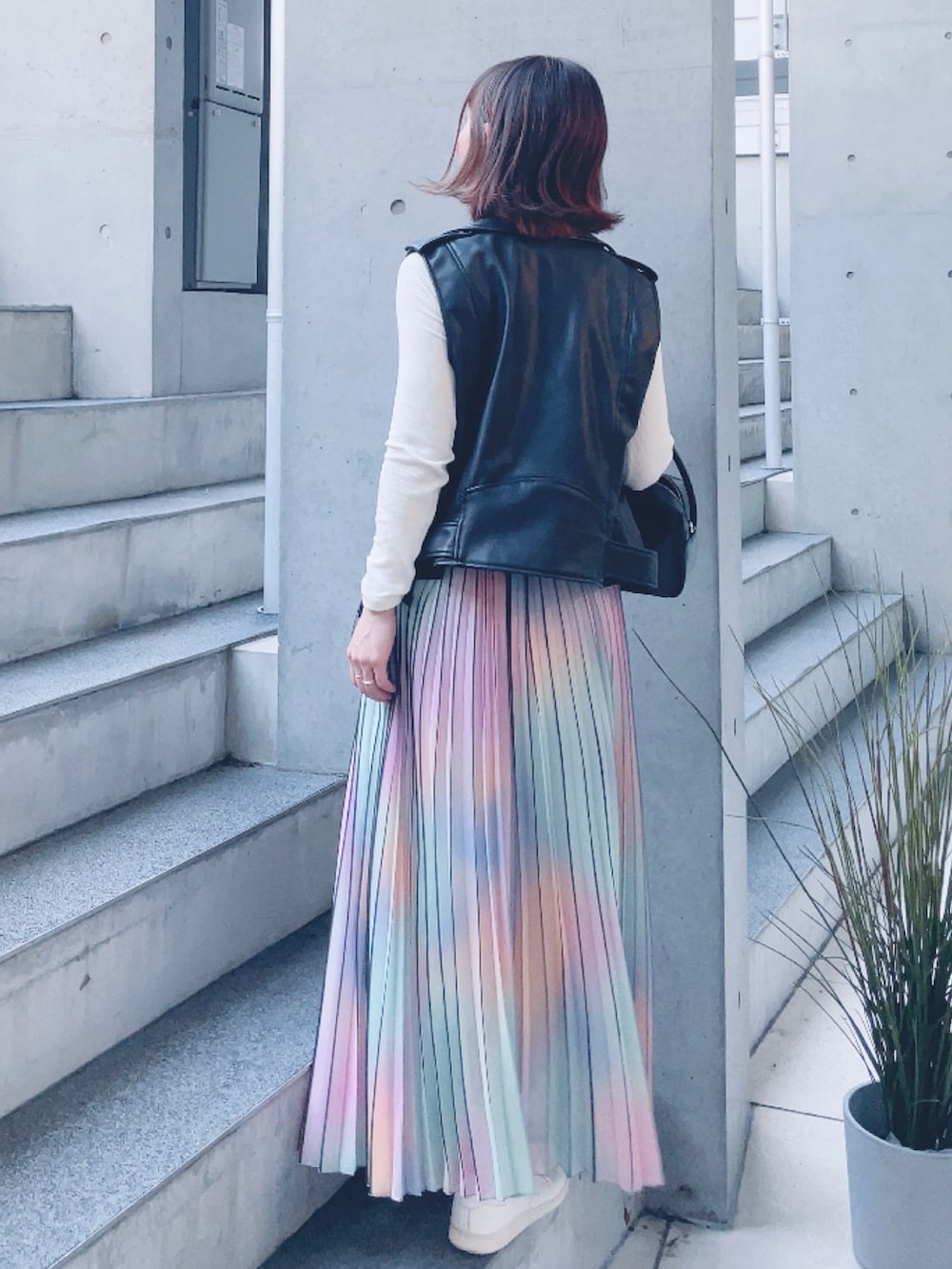 ブラック系のライダースジャケット、ブラック系のハンドバッグ、その他のスカートを着用したレディースの秋コーディネートの4枚目の写真