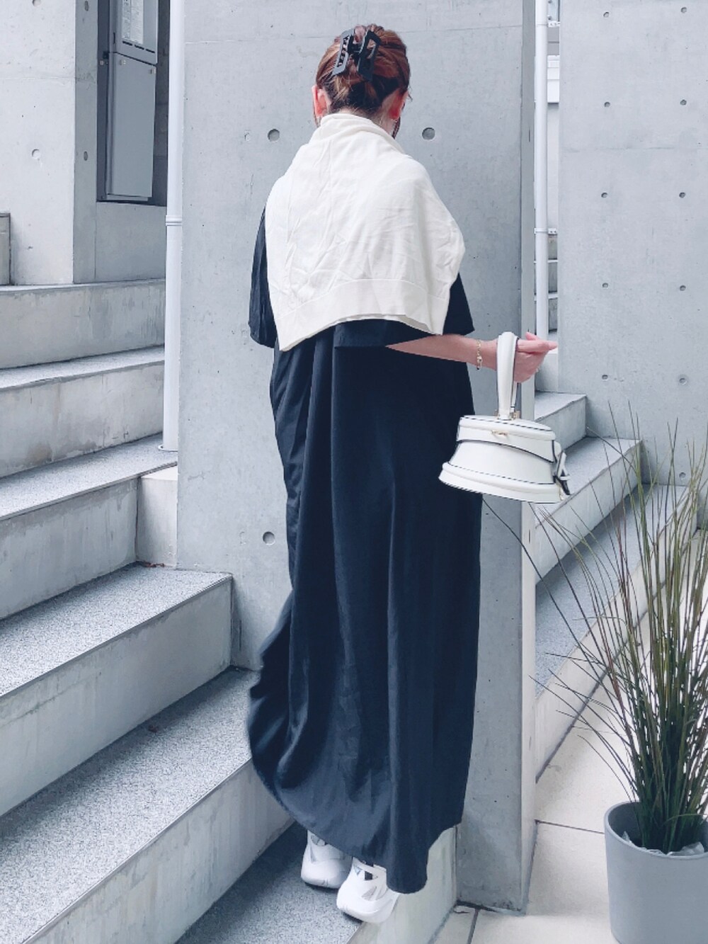 ブラック系のワンピース、ホワイト系のバッグ、ホワイト系のスニーカーを着用したレディースの夏コーディネートの3枚目の写真