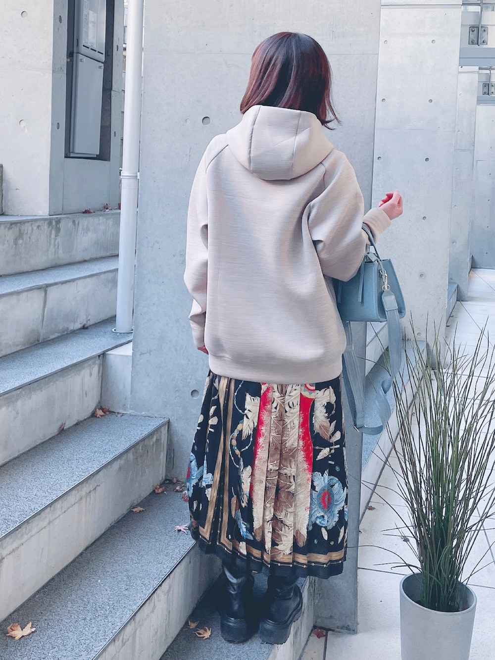 その他のスカート、ブラック系のブーツ、ブルー系のショルダーバッグを着用したレディースの冬コーディネートの2枚目の写真