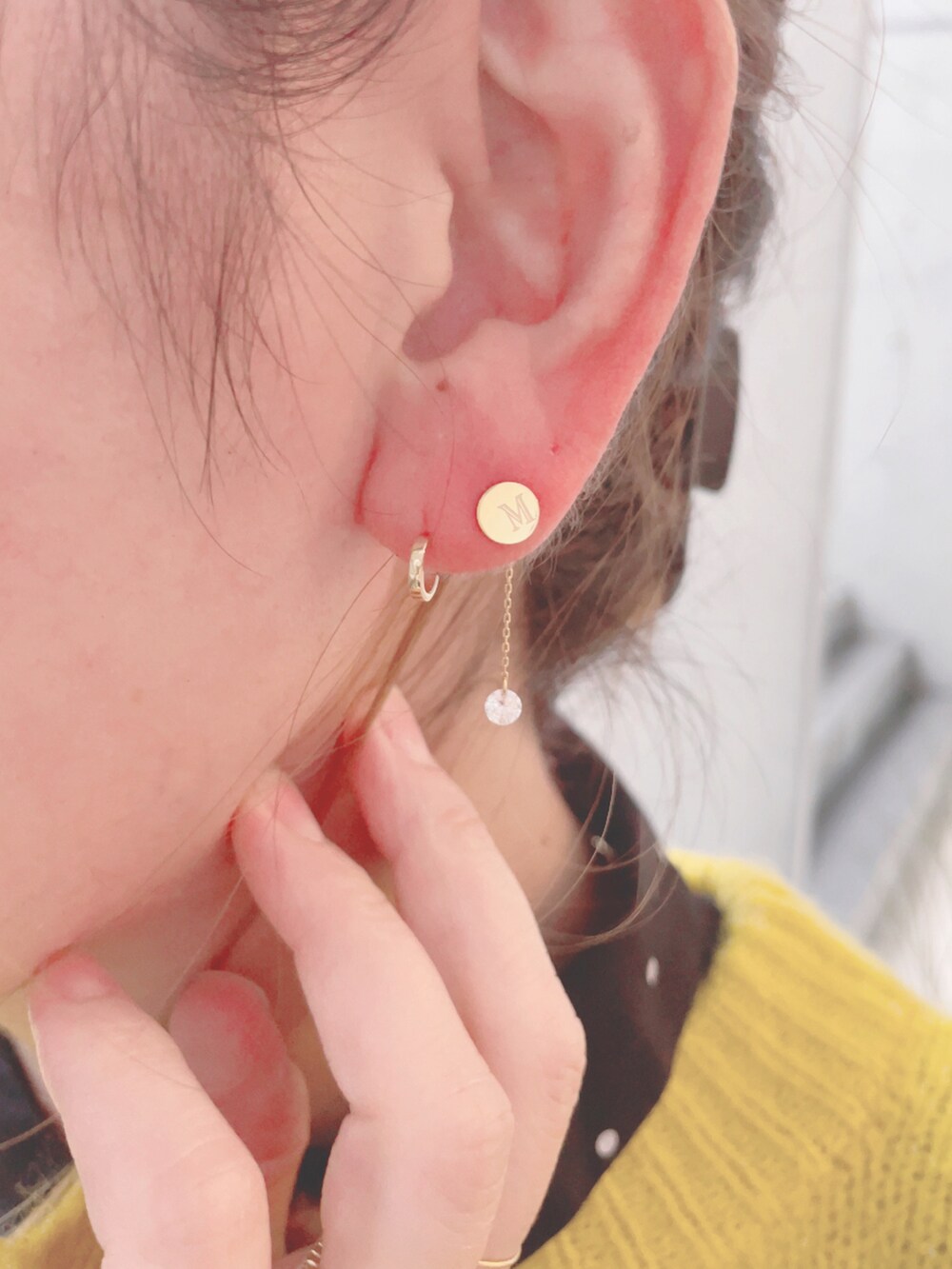 イエロー系のニット/セーター、ブラック系のハンドバッグ、ブラック系のスカートを着用したレディースの秋コーディネートの5枚目の写真