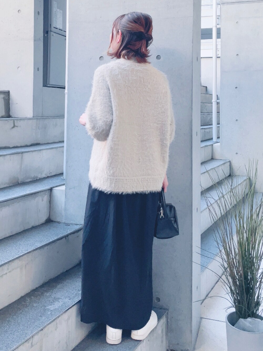 ベージュ系のカーディガン/ボレロ、ブラック系のワンピース、ブラック系のハンドバッグを着用したレディースの冬コーディネートの3枚目の写真