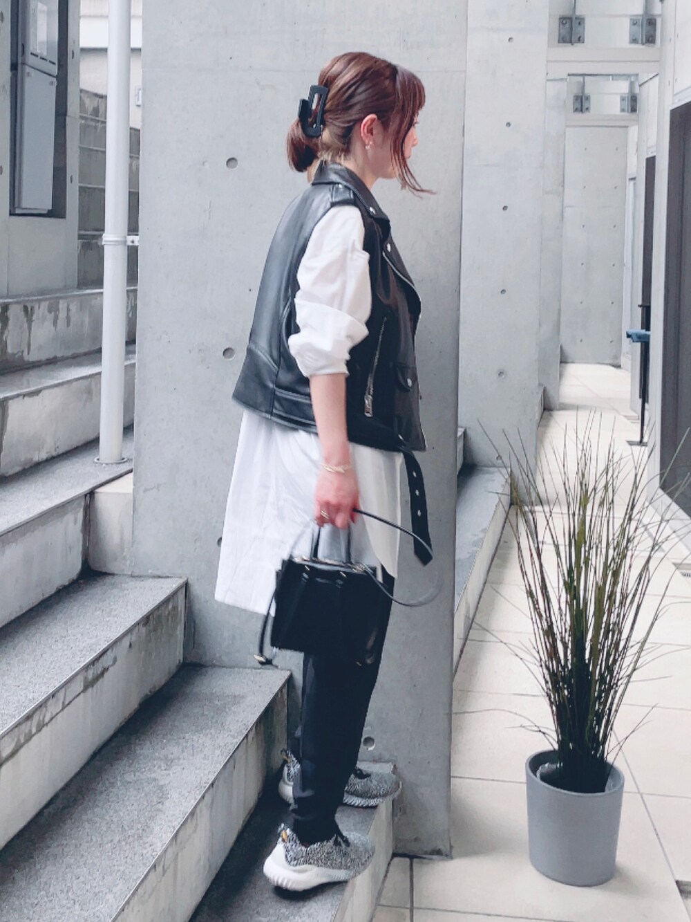 ブラック系のライダースジャケット、ブラック系のベスト、ホワイト系のシャツ/ブラウスを着用したレディースの春コーディネートの2枚目の写真