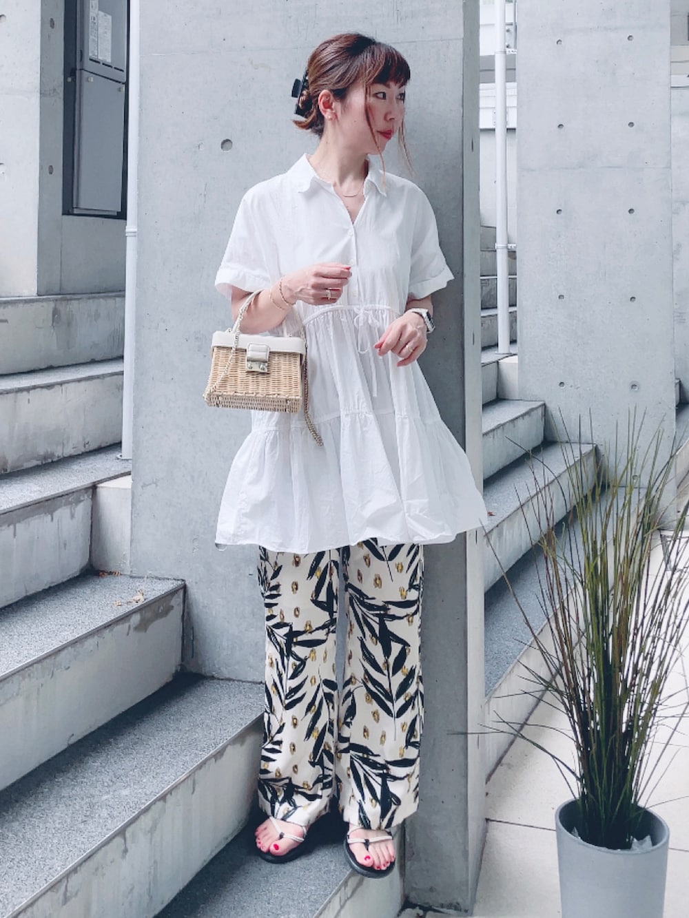 ベージュ系のその他パンツ、ホワイト系のサンダル、ホワイト系のかごバッグを着用したレディースの夏コーディネートの2枚目の写真