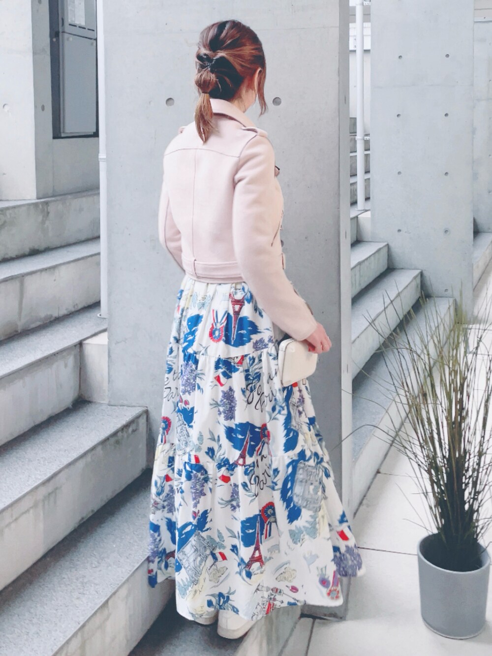 ピンク系のライダースジャケット、ホワイト系のワンピース、ベージュ系のスニーカーを着用したレディースの秋コーディネートの3枚目の写真