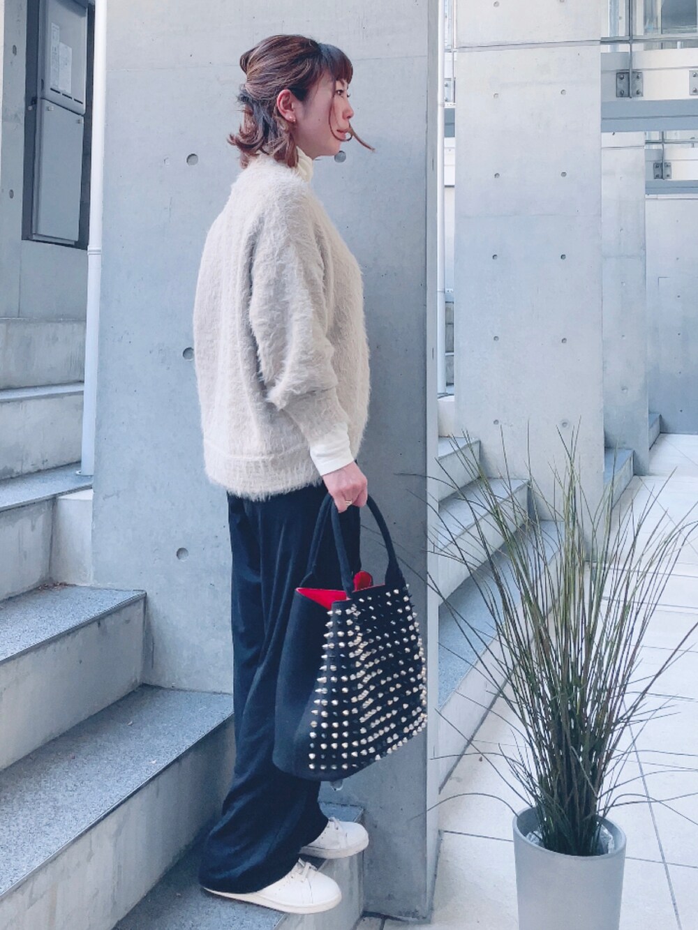 ベージュ系のカーディガン/ボレロ、ブラック系のトートバッグ、ベージュ系のスニーカーを着用したレディースの冬コーディネートの2枚目の写真