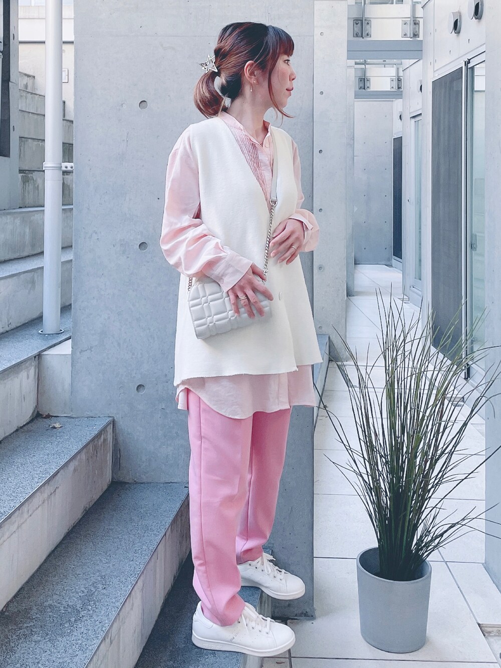 ピンク系のシャツ/ブラウス、ホワイト系のベスト、ピンク系のパンツを着用したレディースの秋コーディネートの2枚目の写真