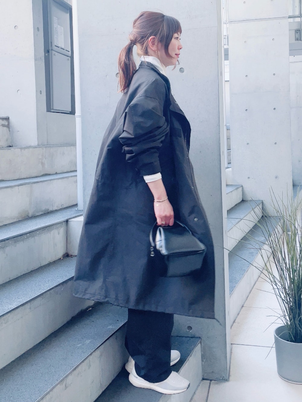 ブラック系のモッズコート、ブラック系のサロペット/オーバーオール、ブラック系のハンドバッグを着用したレディースの春コーディネートの2枚目の写真