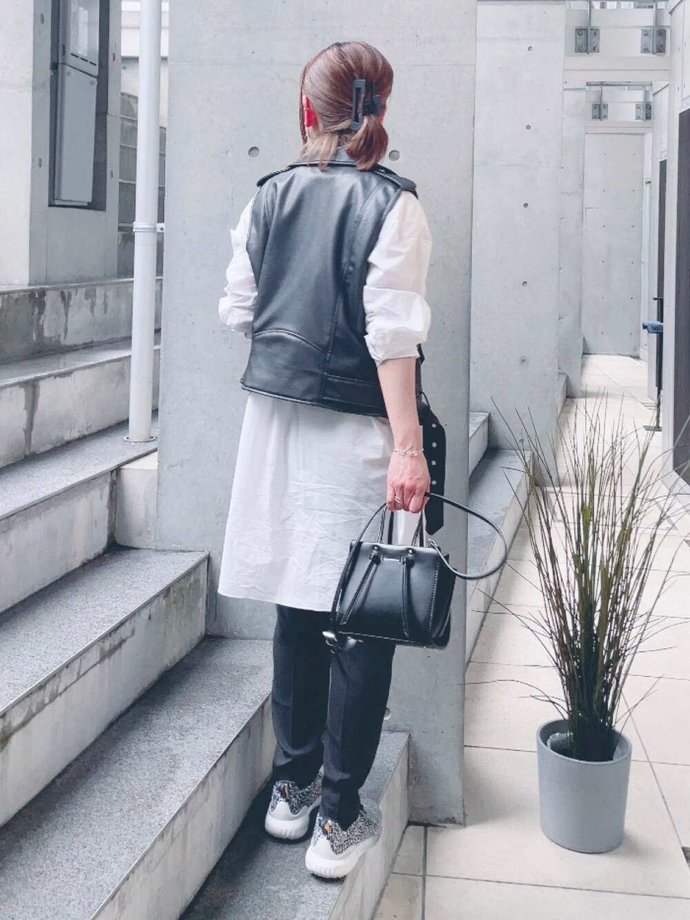 ブラック系のライダースジャケット、ブラック系のベスト、ホワイト系のシャツ/ブラウスを着用したレディースの春コーディネートの3枚目の写真