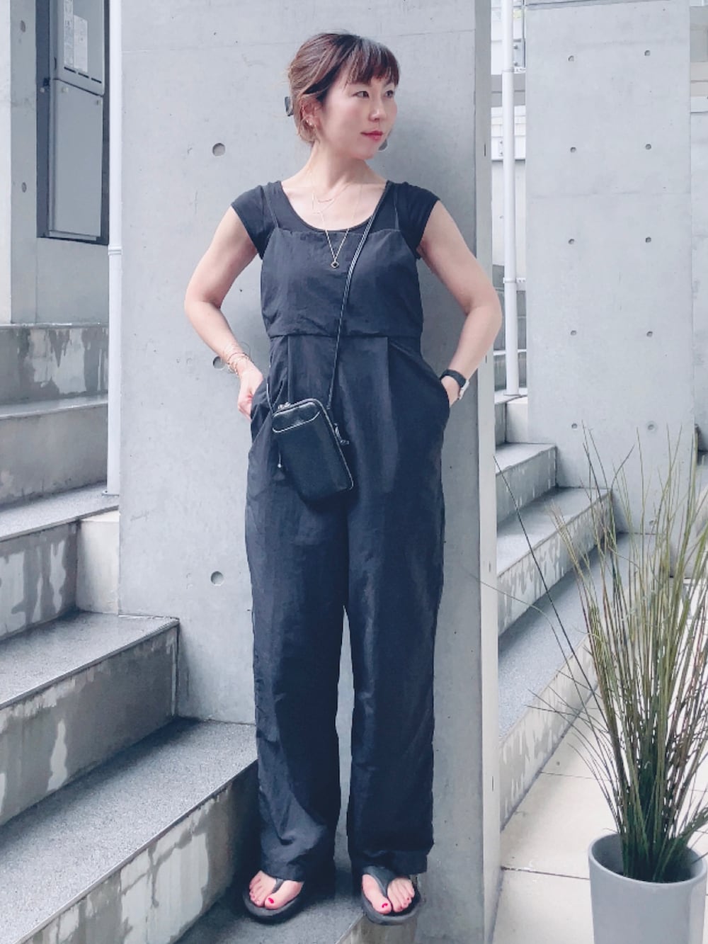 ブラック系のサロペット/オーバーオール、ブラック系のサンダル、ブラック系のポーチを着用したレディースの夏コーディネートの3枚目の写真