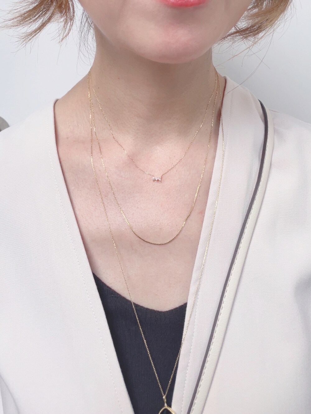 ベージュ系のベスト、ホワイト系のショルダーバッグ、ブラック系のサンダルを着用したレディースの夏コーディネートの5枚目の写真