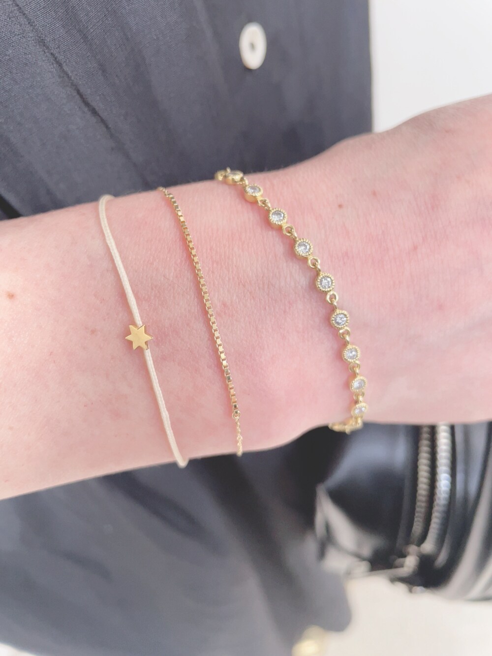 ブラック系のワンピース、ブラック系のハンドバッグ、ゴールド系のスニーカーを着用したレディースの春コーディネートの4枚目の写真