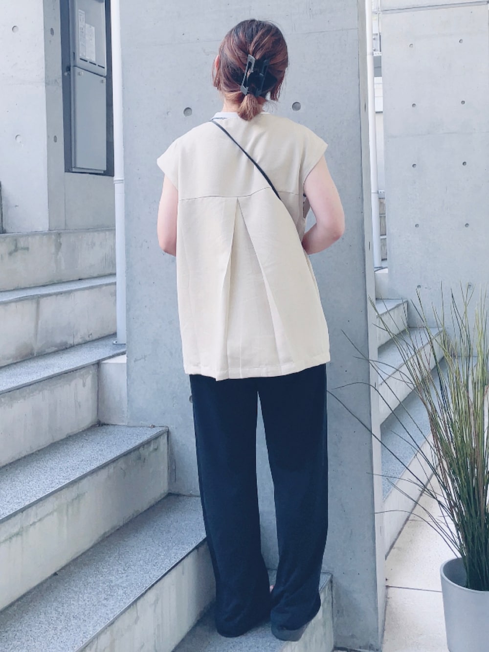 ホワイト系のベスト、ホワイト系のTシャツ/カットソー、ブラック系のサンダルを着用したレディースの夏コーディネートの3枚目の写真