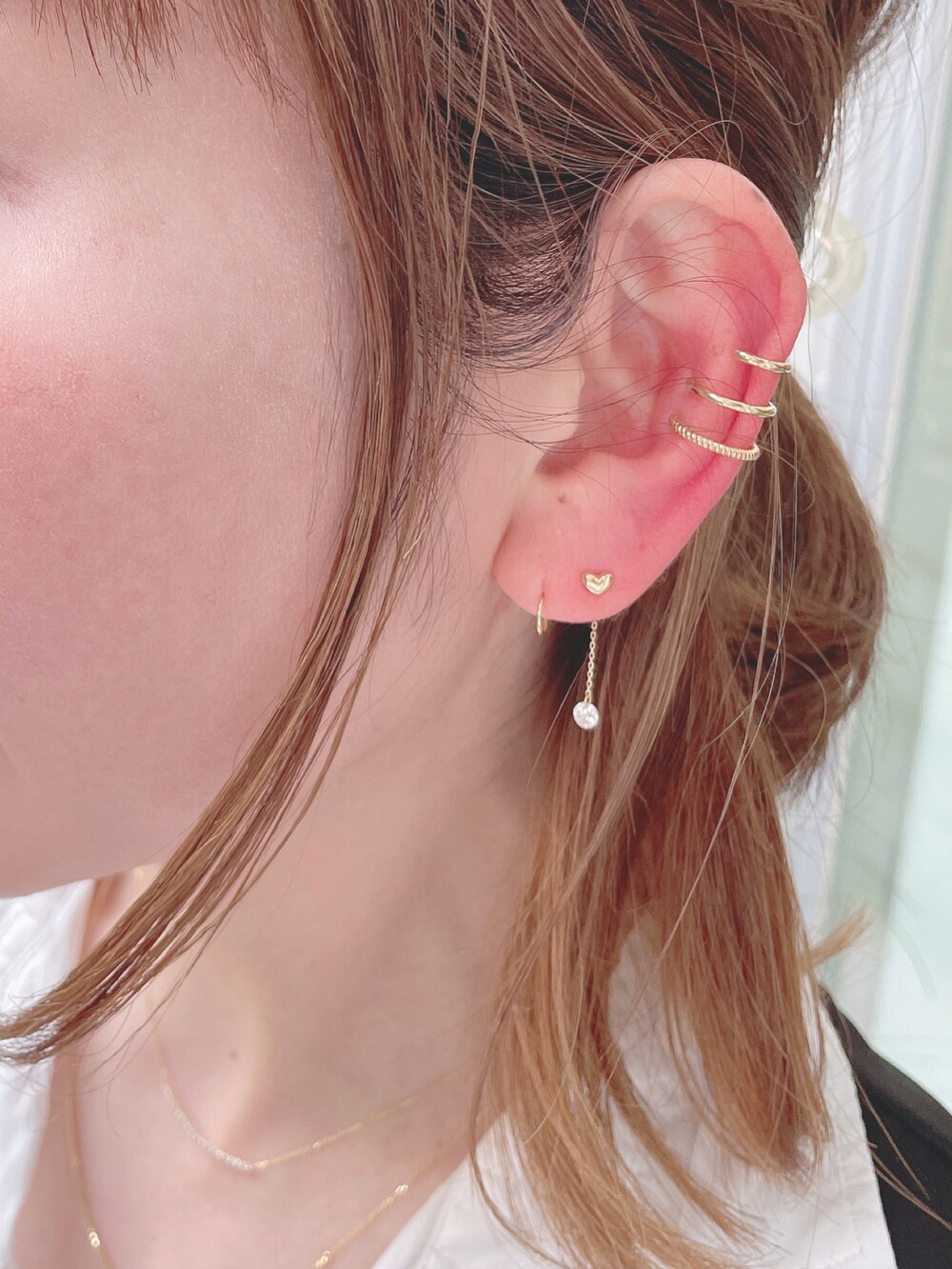 ブラック系のベスト、ホワイト系のシャツ/ブラウス、ベージュ系のスカートを着用したレディースの春コーディネートの5枚目の写真