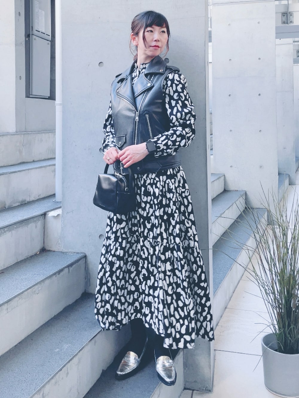 ブラック系のワンピース、ブラック系のライダースジャケットを着用したレディースの冬コーディネートの2枚目の写真