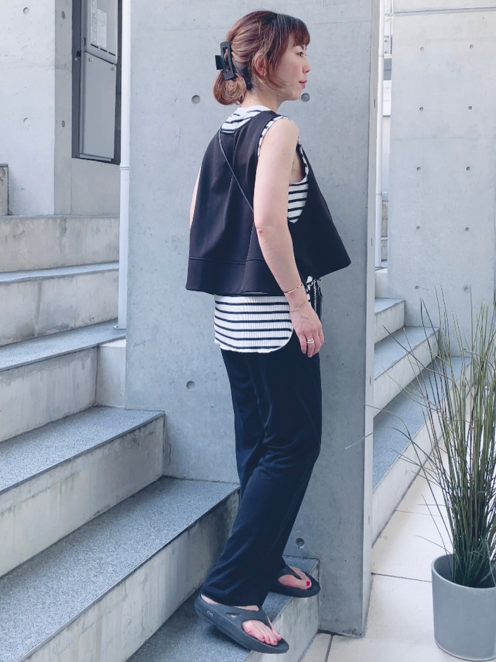 ホワイト系のTシャツ/カットソー、ブラック系のベスト、ブラック系のサンダルを着用したレディースの夏コーディネートの3枚目の写真