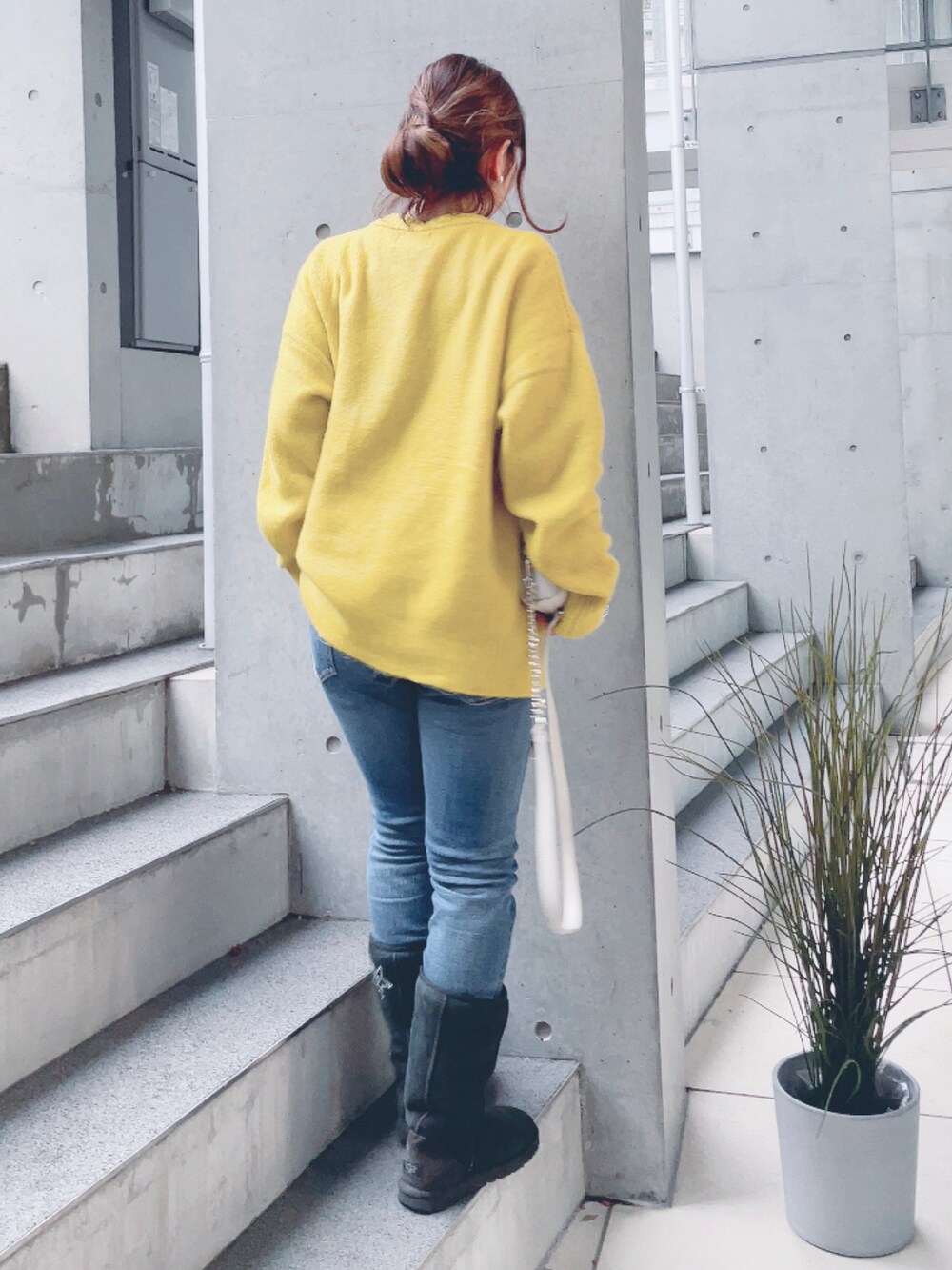 ブルー系のデニムパンツ、イエロー系のニット/セーターを着用したレディースの冬コーディネートの3枚目の写真