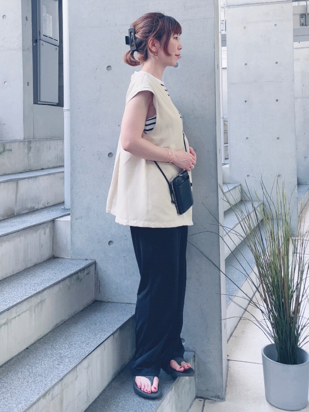 ホワイト系のベスト、ホワイト系のTシャツ/カットソー、ブラック系のサンダルを着用したレディースの夏コーディネートの2枚目の写真