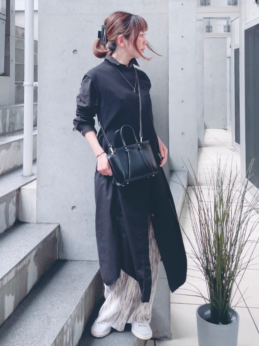 ブラック系のシャツワンピース、ベージュ系のその他パンツ、ゴールド系のブレスレットを着用したレディースの春コーディネートの2枚目の写真