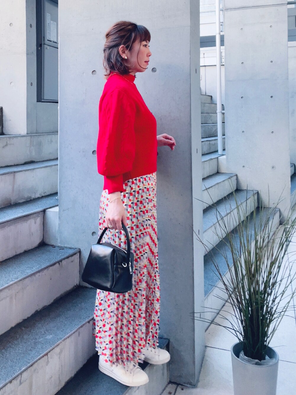 ブラック系のハンドバッグ、その他のスカート、ベージュ系のスニーカーを着用したレディースの冬コーディネートの2枚目の写真