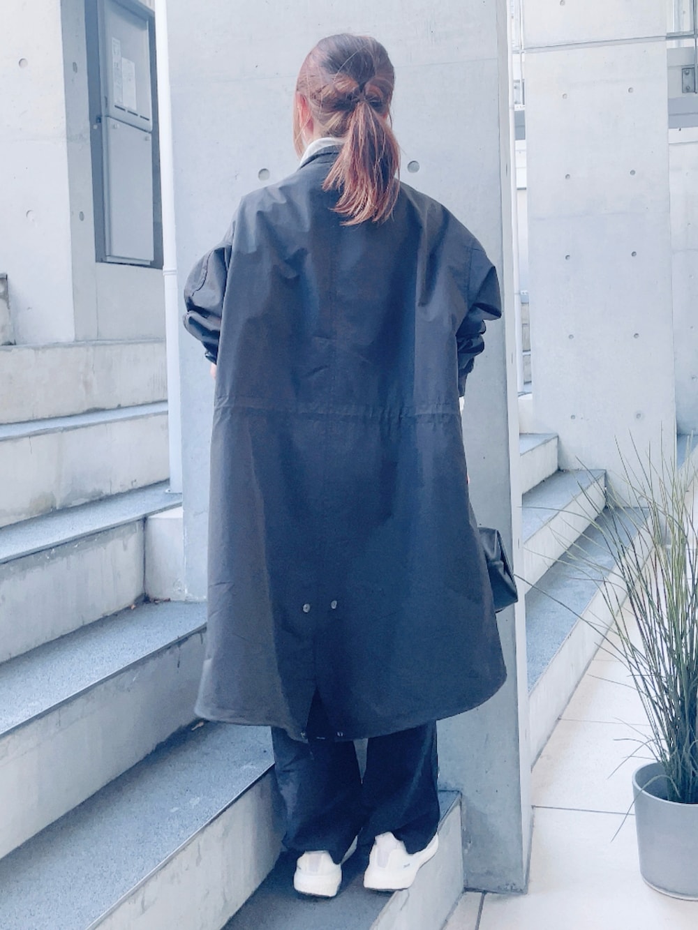 ブラック系のモッズコート、ブラック系のサロペット/オーバーオール、ブラック系のハンドバッグを着用したレディースの春コーディネートの3枚目の写真