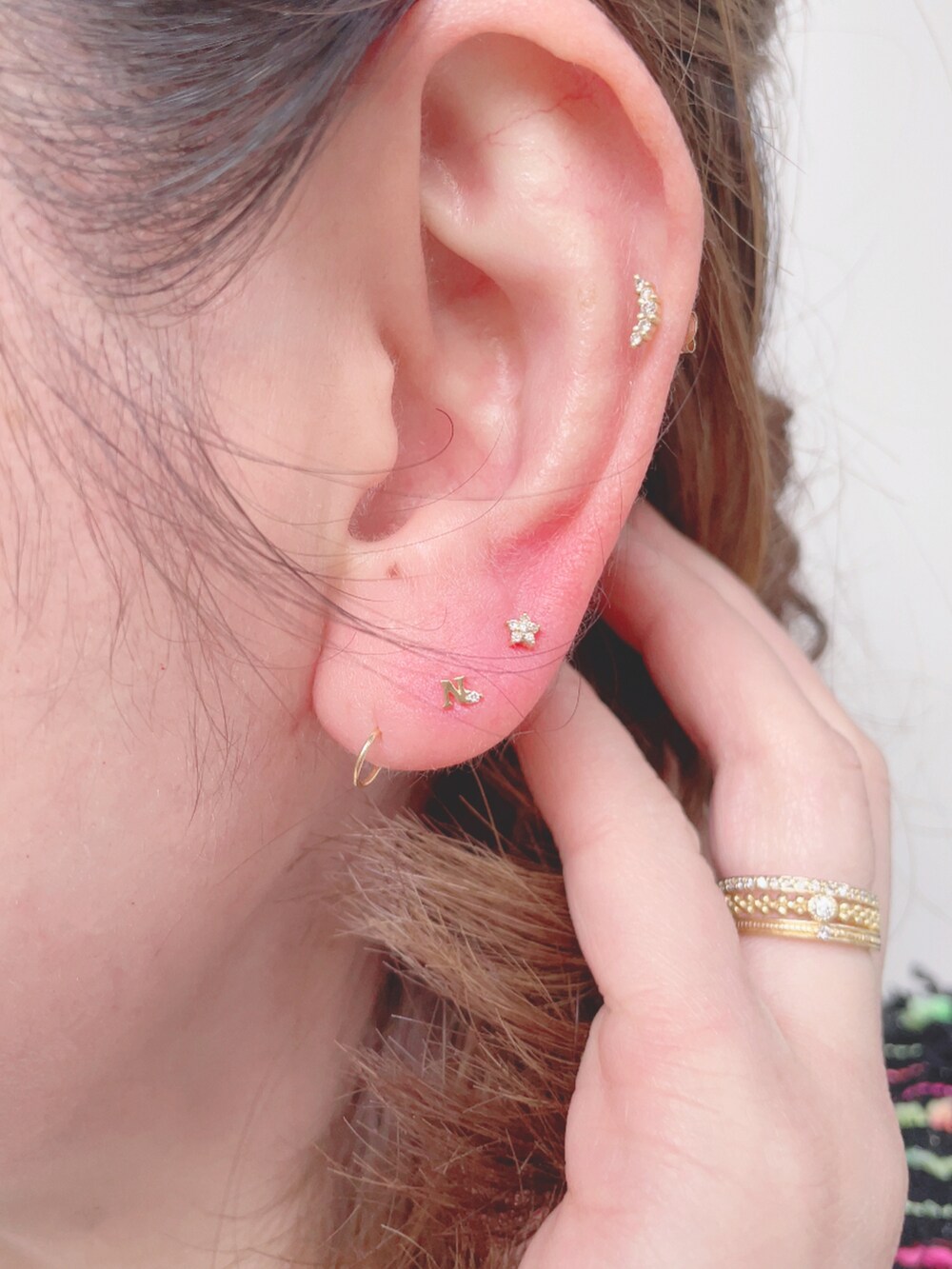 ホワイト系のTシャツ/カットソー、ベージュ系のスカート、ゴールド系のピアス（片耳用）を着用したレディースの春コーディネートの5枚目の写真