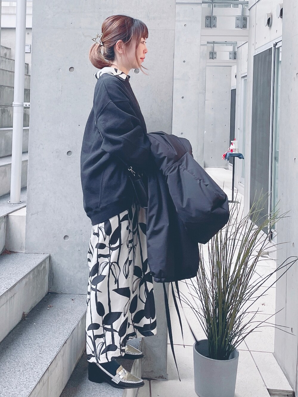 ブラック系のスウェット、ホワイト系のシャツワンピース、ブラック系のダウンジャケット/コートを着用したレディースの冬コーディネートの2枚目の写真