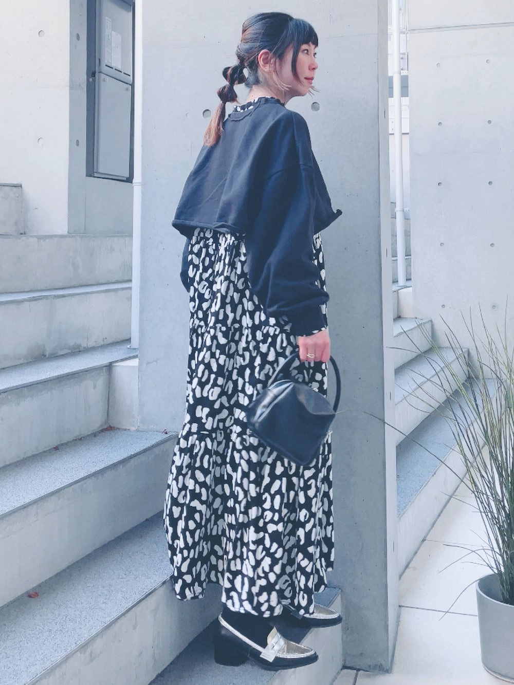 ブラック系のワンピース、ブラック系のスウェット、ブラック系のハンドバッグを着用したレディースの冬コーディネートの2枚目の写真