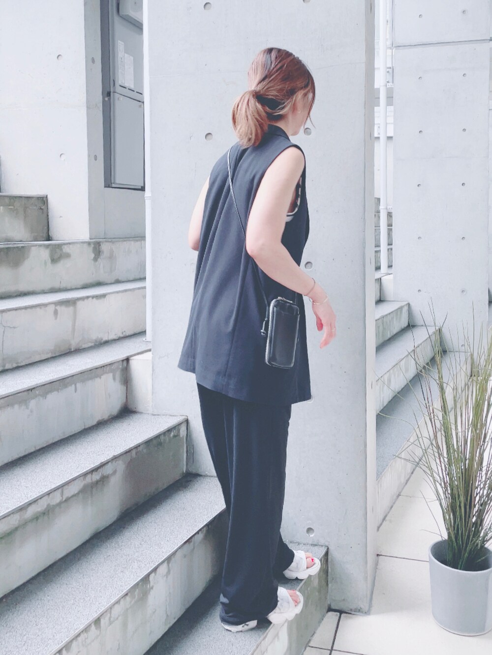 ホワイト系のサンダル、ホワイト系のTシャツ/カットソー、ブラック系のポーチを着用したレディースの秋コーディネートの3枚目の写真