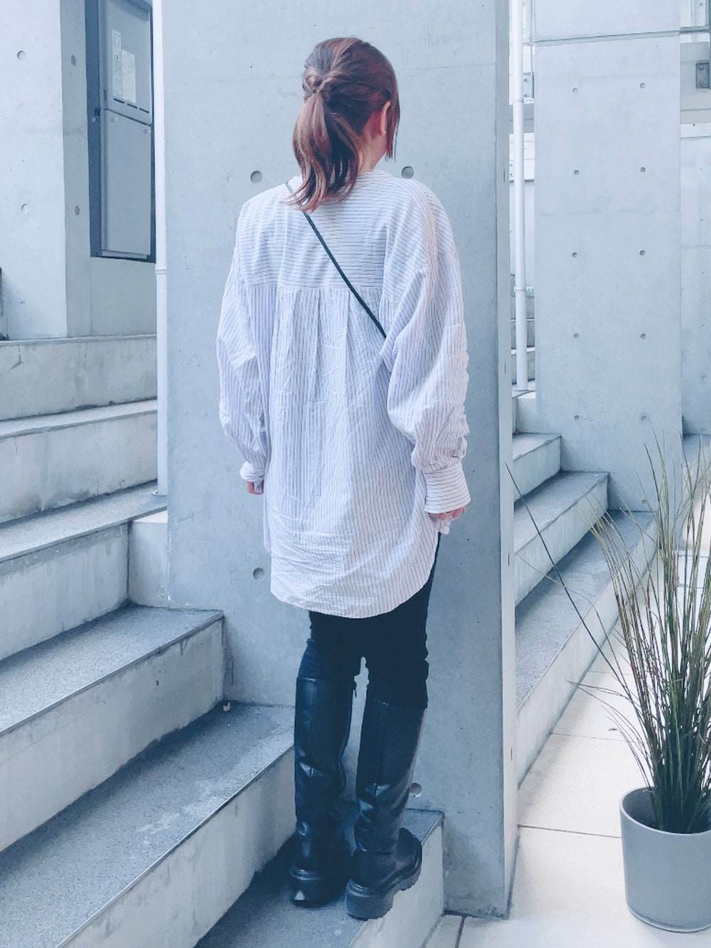 ピンク系のシャツ/ブラウス、ブラック系のブーツ、ブラック系のポーチを着用したレディースの春コーディネートの3枚目の写真