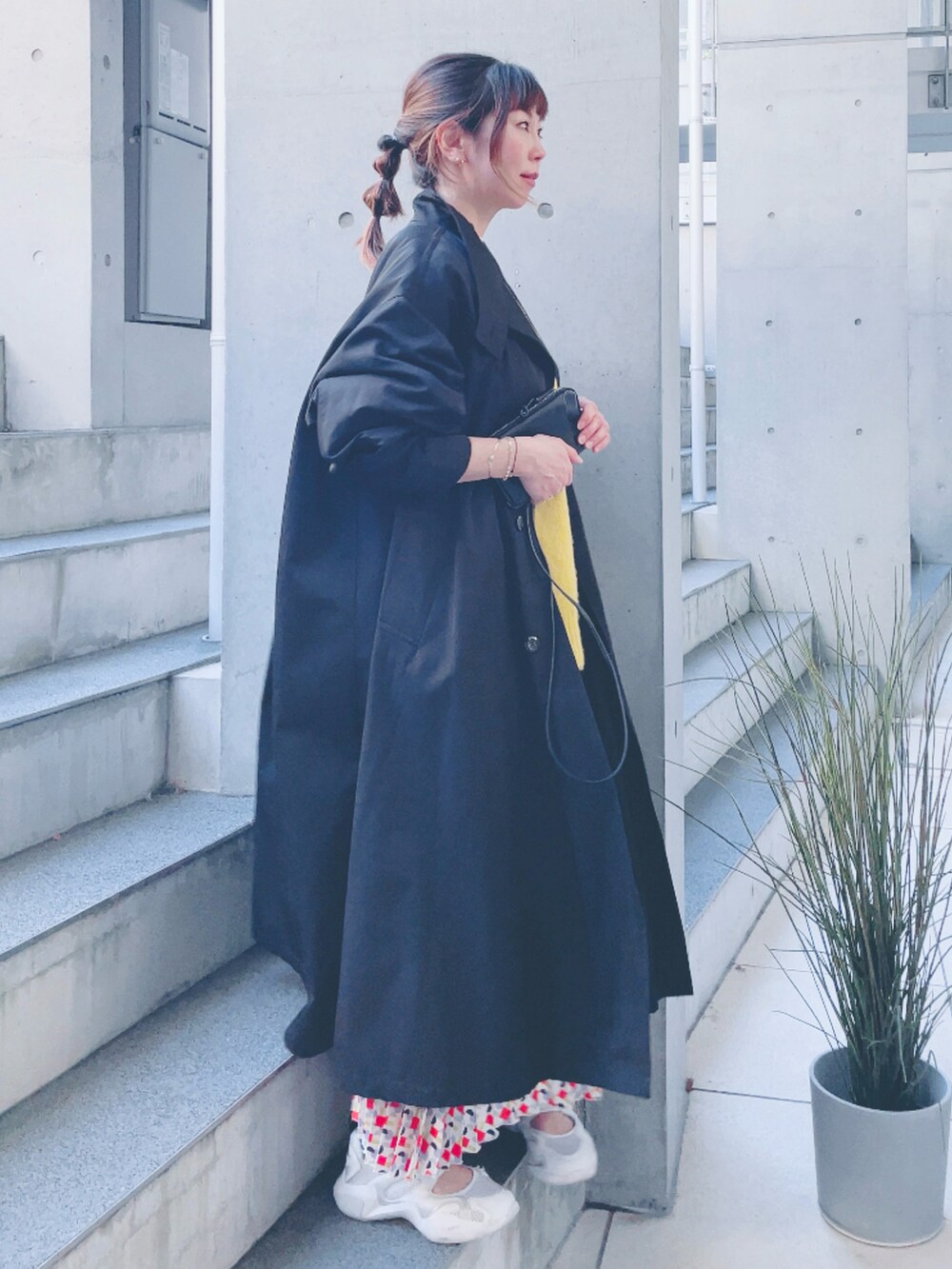 ブラック系のその他アウター、イエロー系のニット/セーター、その他のスカートを着用したレディースの秋コーディネートの2枚目の写真