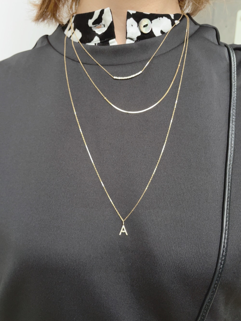 ブラック系のワンピース、ブラック系のベスト、ホワイト系のスニーカーを着用したレディースの春コーディネートの4枚目の写真