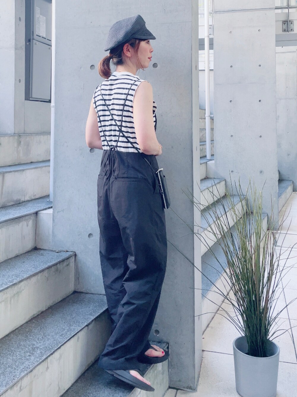ブラック系のサロペット/オーバーオール、ホワイト系のTシャツ/カットソー、ブラック系のサンダルを着用したレディースの夏コーディネートの2枚目の写真
