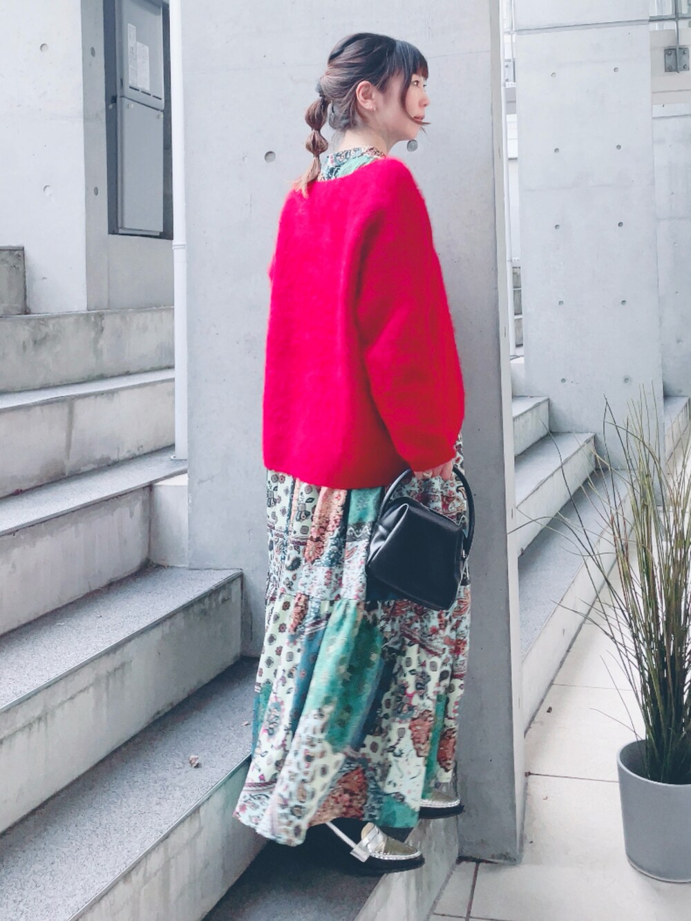 グリーン系のワンピース、ブラック系のハンドバッグ、シルバー系のローファーを着用したレディースの冬コーディネートの2枚目の写真