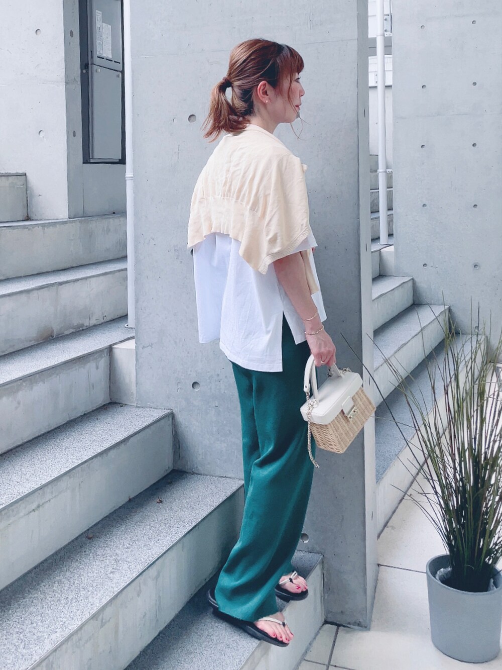 グレー系のTシャツ/カットソー、グリーン系のその他パンツ、ホワイト系のかごバッグを着用したレディースの夏コーディネートの3枚目の写真