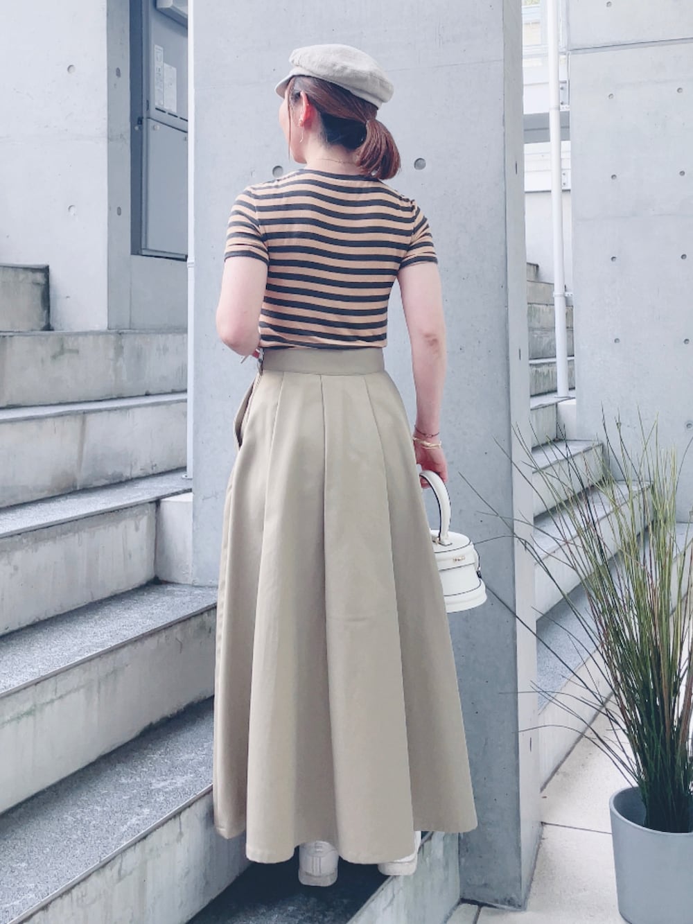 ベージュ系のスカート、ホワイト系のバッグ、ベージュ系のスニーカーを着用したレディースの夏コーディネートの3枚目の写真
