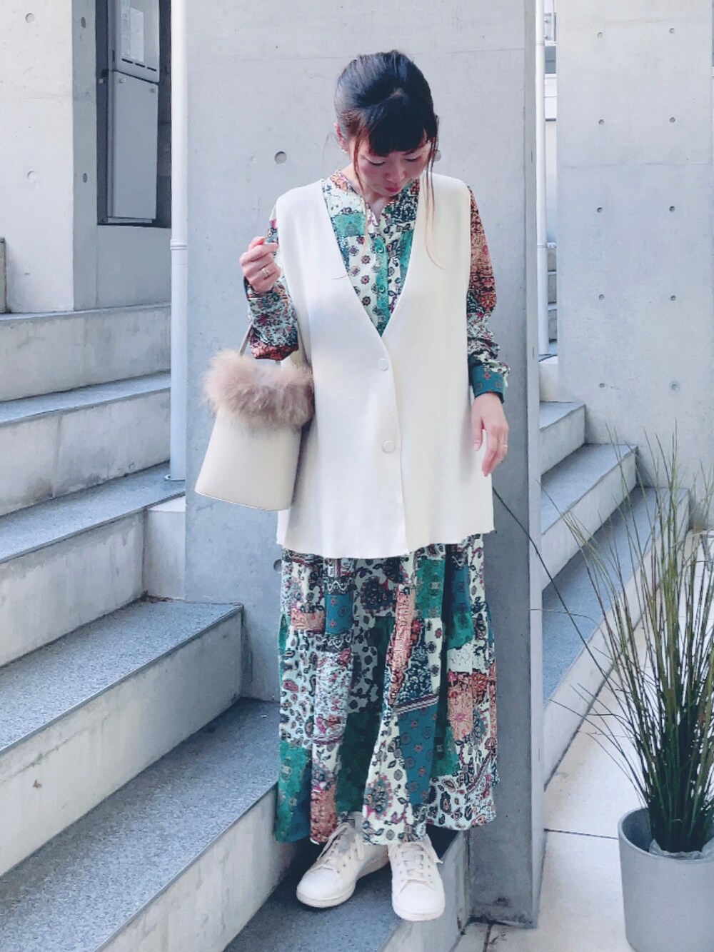 グリーン系のワンピース、ホワイト系のショルダーバッグ、ベージュ系のスニーカーを着用したレディースの秋コーディネートの2枚目の写真