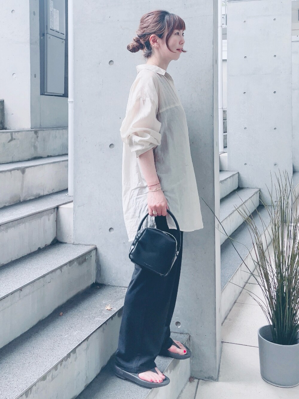 ベージュ系のシャツ/ブラウス、ブラック系のハンドバッグを着用したレディースの夏コーディネートの2枚目の写真