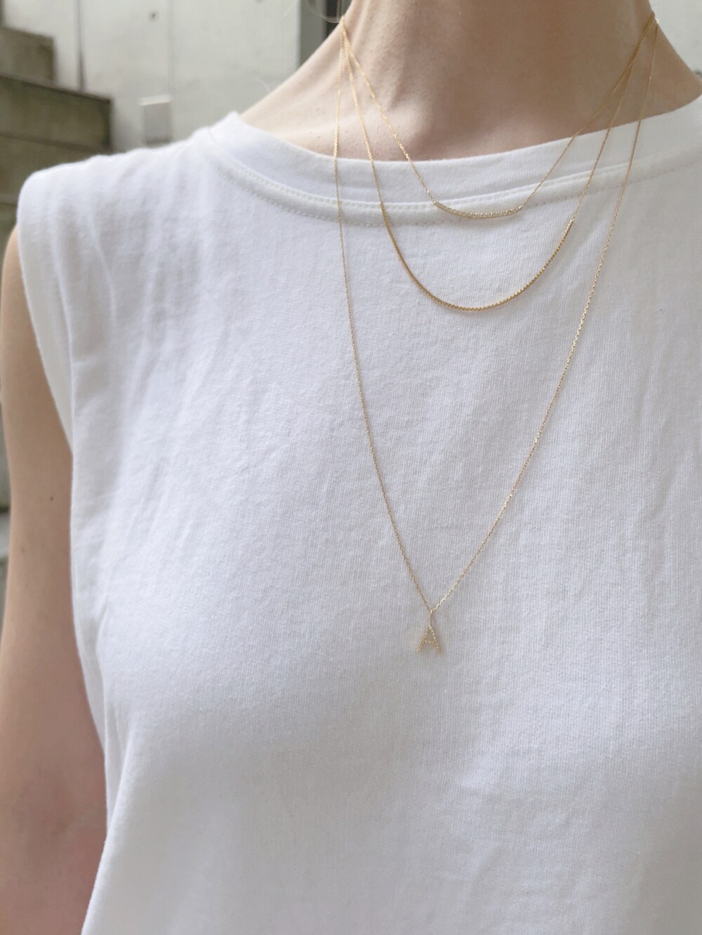 ホワイト系のタンクトップ、ブルー系のショルダーバッグ、イエロー系のその他パンツを着用したレディースの夏コーディネートの4枚目の写真