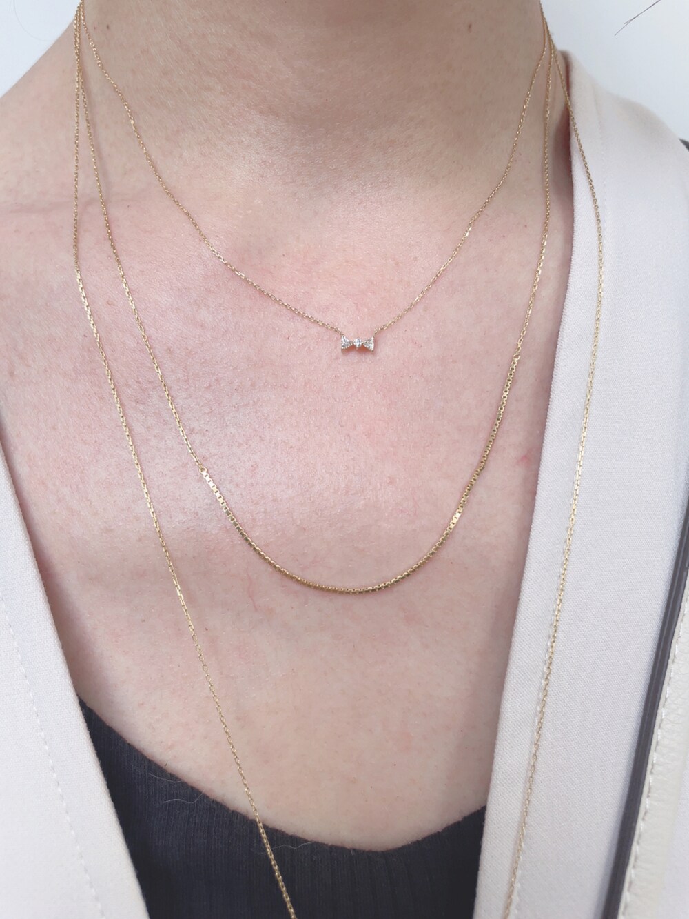 ベージュ系のベスト、ホワイト系のショルダーバッグ、ブラック系のサンダルを着用したレディースの夏コーディネートの4枚目の写真