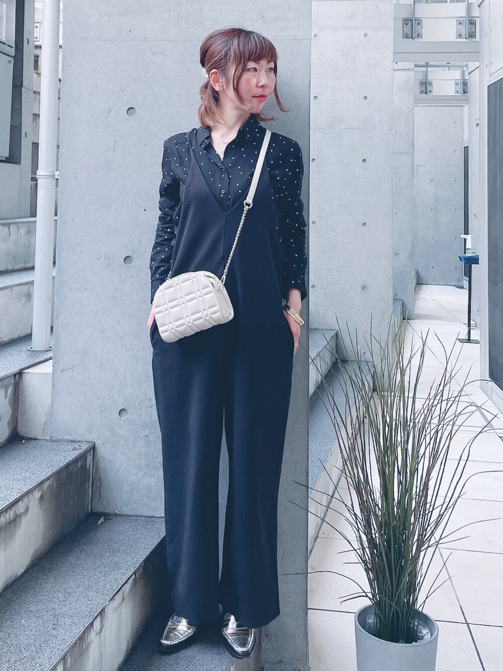 ブラック系のつなぎ/オールインワン、ゴールド系のショルダーバッグ、シルバー系のローファーを着用したレディースの冬コーディネートの2枚目の写真