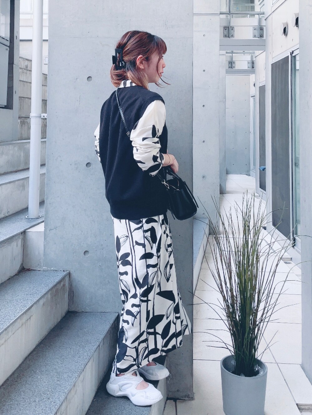 ホワイト系のスニーカー、ホワイト系のシャツワンピース、ブラウン系のデジタル腕時計を着用したレディースの春コーディネートの2枚目の写真