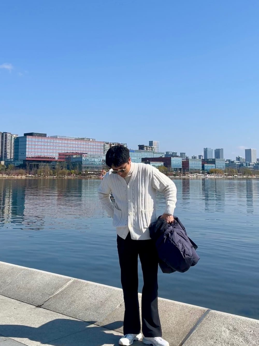 ブルー系のダウンジャケット/コート、ホワイト系のシューズ、ブラック系のパンツを着用したメンズの冬コーディネートの2枚目の写真