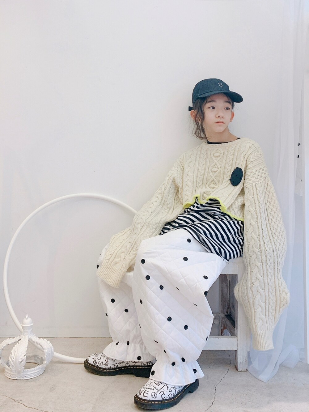 ホワイト系のパンツ、ホワイト系のシューズ、ホワイト系のニット/セーターを着用したキッズの秋コーディネートの2枚目の写真