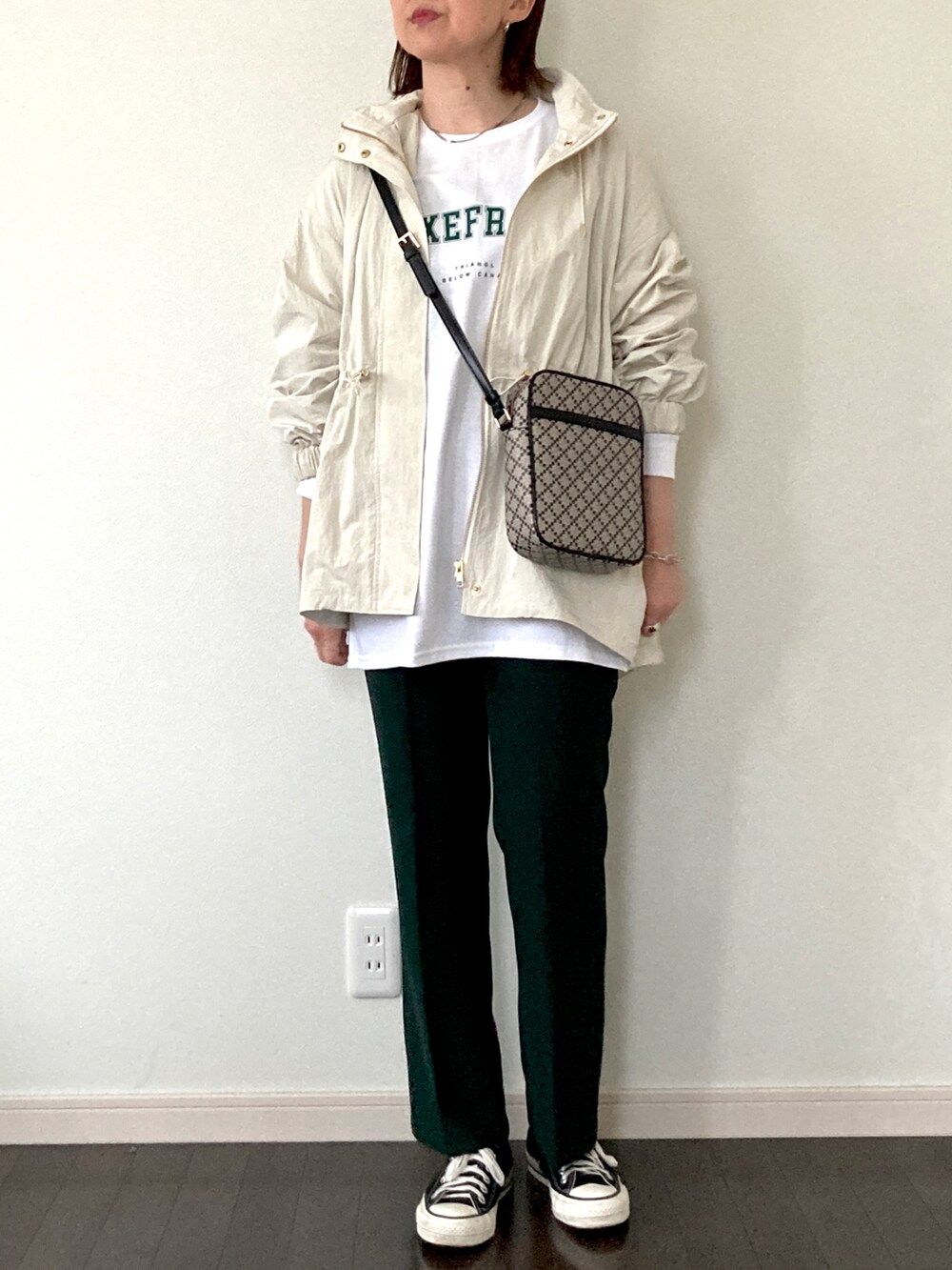 ホワイト系のTシャツ/カットソー、ブラック系のショルダーバッグ、グリーン系のその他パンツを着用したレディースの春コーディネートの2枚目の写真